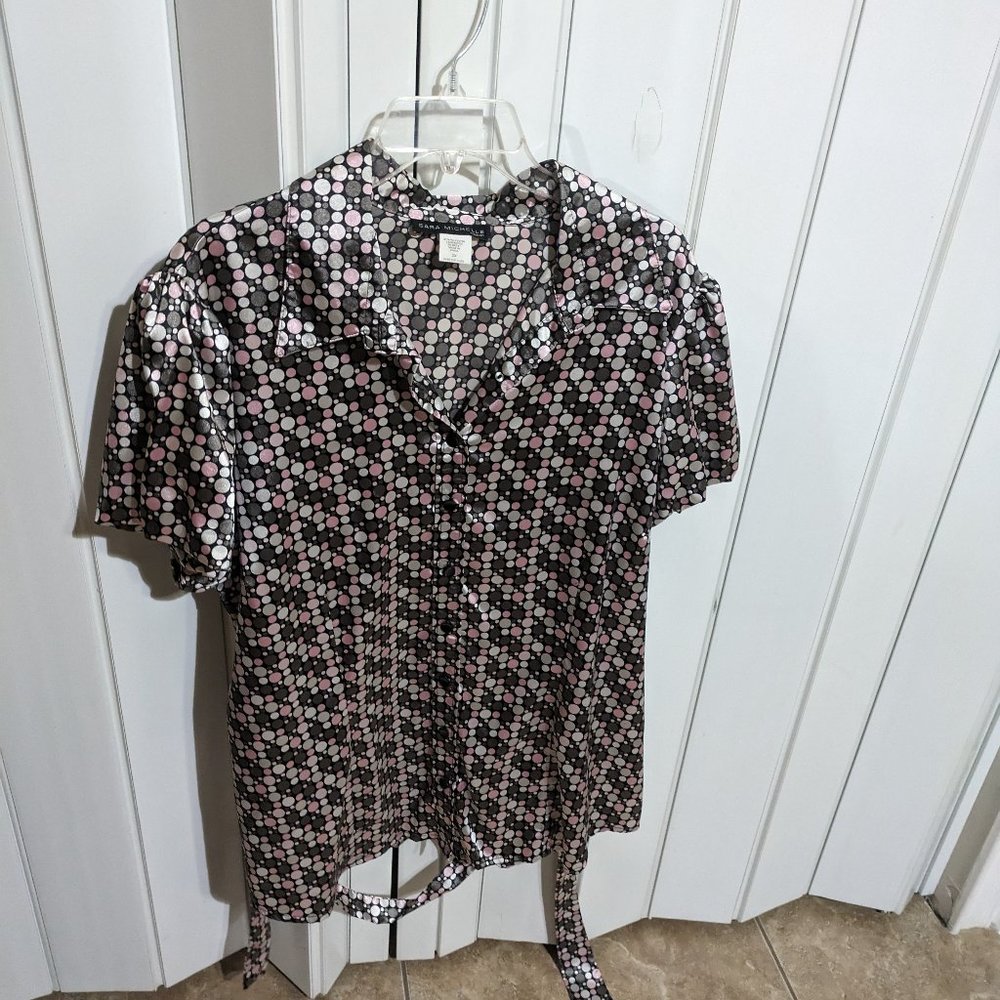 Women's blouse with a fabric belt for around the waist.